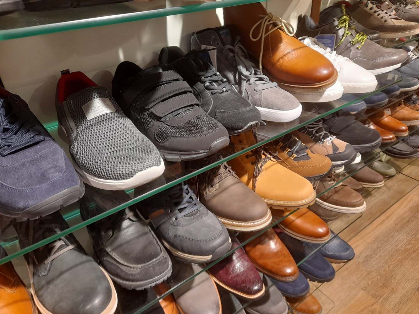 Unsere Herrenstiefel aus Leder in einem Schuhregal aus Glas