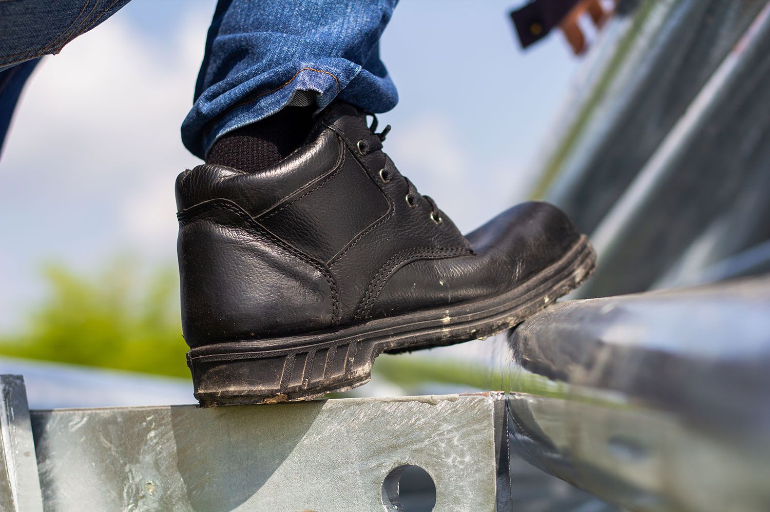 Ein schwarzer Lederschuh mit einer blauen Jeans